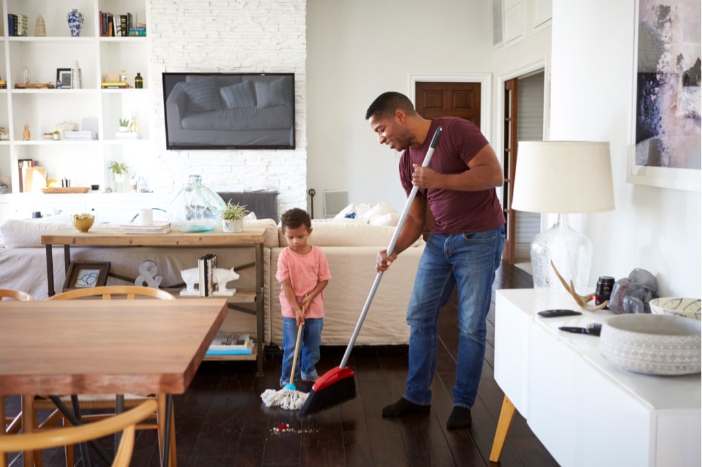 Dad and son are cleaning the floor together. One of the best ways to get kids to do chores is to have them perform the chores alongside you.