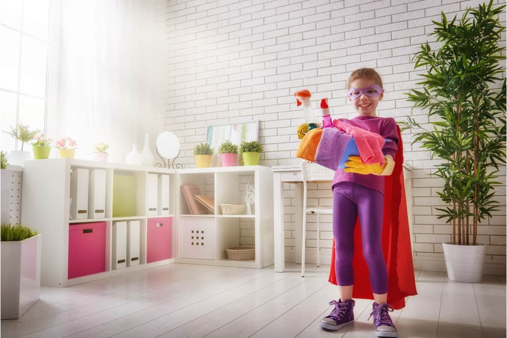 Make cleaning fun for kids by pretending and playing dress up. This girl is dressed like a superhero.
