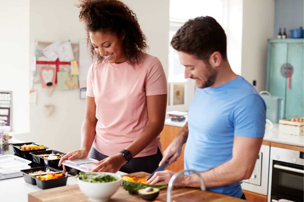 This man and woman are meal prepping to save time on cooking meals during the week.