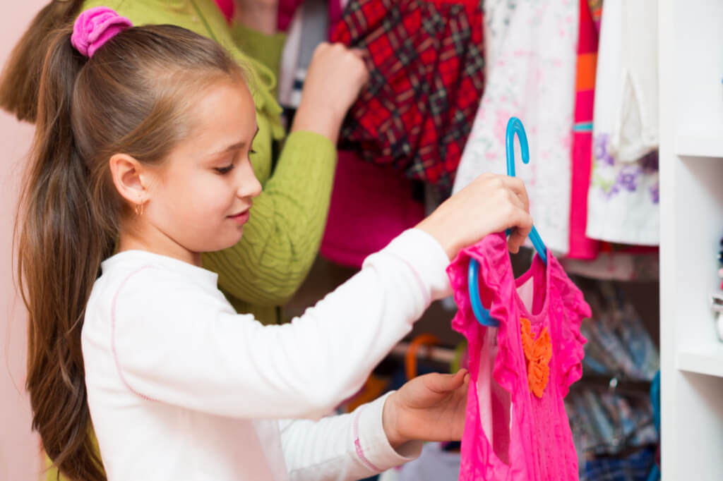 Learn how to do laundry faster. This girl is putting her own clothes away which cuts down on time doing laundry for her mom.