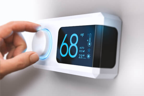 Person is turning thermostat down to 68 degrees to get better quality sleep.