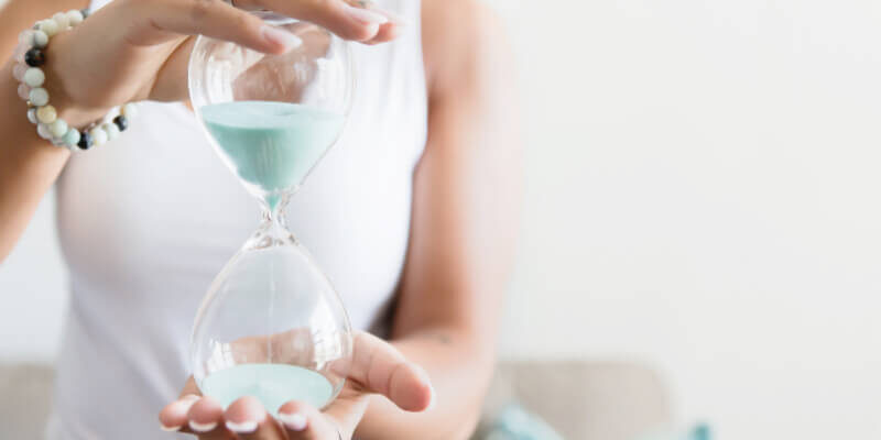 In order to be more productive, you need to be aware of how you spend your time. This woman is holding a sand timer.
