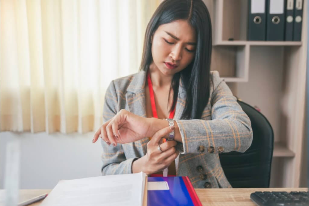 woman is looking at her watch to see how much time she has left to get her work done