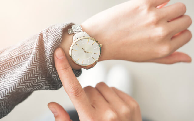 Woman looking at her watch to find out how much time she has left. Being aware of time is important to be more productive.